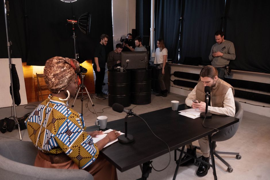Diverse team in a studio setting recording a podcast with professional equipment.